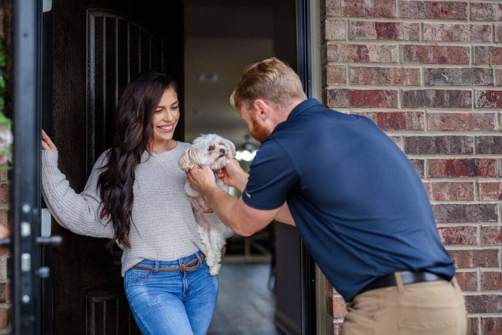 Happy Dallas homeowner with a friendly Firehouse Roofing technician.